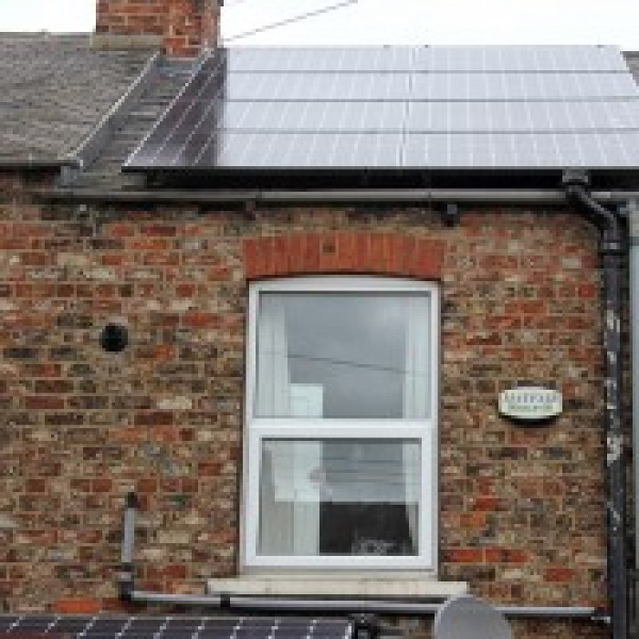 Solar panels on the roof of a red brick terraced house