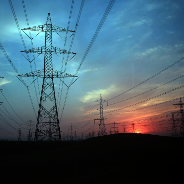 Electricity pylons stretching away into the distance against a beutiful and dramatic blue and red sky